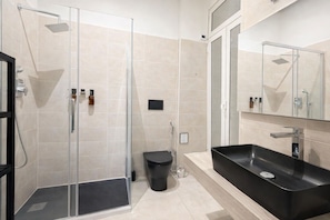 A modern bathroom with a glass-enclosed shower, a black sink, and a mirror above the sink. - BORGO APARTMENT IMPERO VATICANO (Roma)