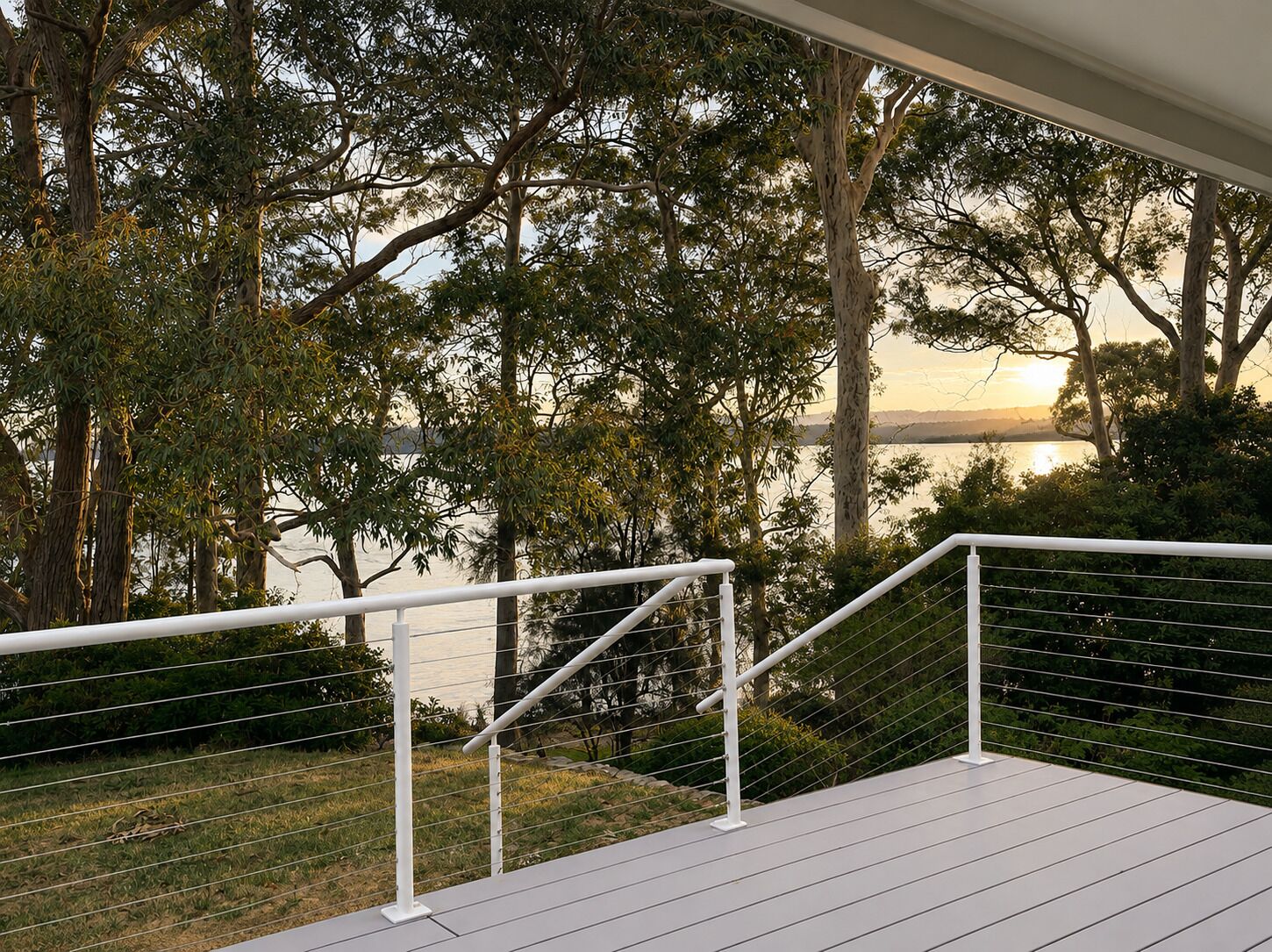A balcony with a railing overlooking a body of water and trees.