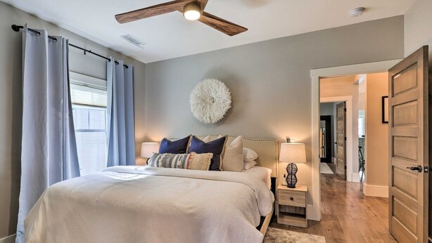 A bedroom with a bed, bedside lamps, a ceiling fan, and a large fluffy wall decoration. - Family Home, Hot Tub, Near Whiskey Row (Prescott)