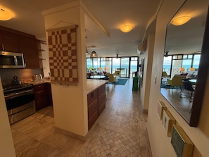 A modern kitchen with a checkered towel, a microwave, and a toaster. - Oceanview 2BR/2BA condo with pool, AC, balcony, and beach access-Kanai A Nalu 317 (Wailuku)