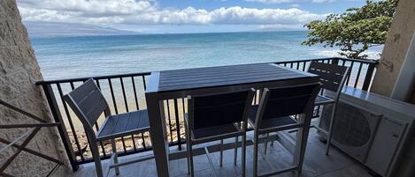 Un balcón con mesa y sillas con vistas al mar.