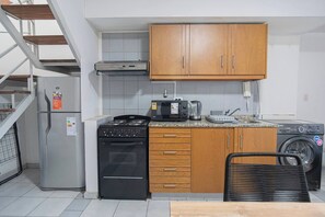 Eine kleine Küche mit Herd, Mikrowelle, Backofen und Waschmaschine.