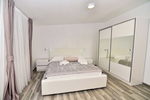 A modern bedroom with a large bed, a wardrobe, and a mirror. - Charming 2-Bedroom Apartment with Stunning Views in Vir (Vir)