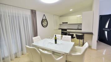 A modern kitchen with white cabinets, a black countertop, and a sink.