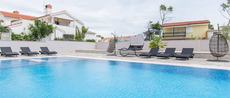 A swimming pool with lounge chairs and a canopy.