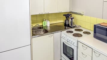 A kitchen with white cabinets, a stove, and a sink.