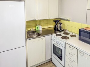 A kitchen with white cabinets, a stove, and a sink.