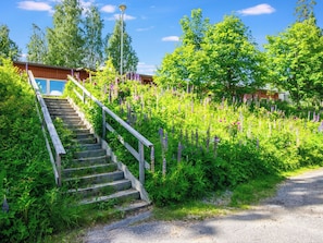 A staircase leading to a building surrounded by lush greenery and flowering plants.