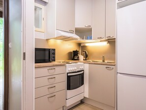 A compact kitchen with a microwave, coffee maker, and oven.