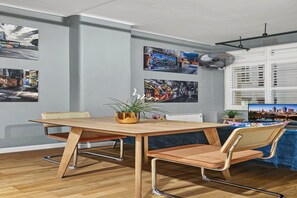 A dining area with a wooden table, two chairs, and a potted plant. - Temple Court Suite in Melbourne CBD (Melbourne)