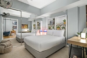 A modern bedroom with a large bed, bedside tables, a desk, and a mirrored closet. - Temple Court Suite in Melbourne CBD (Melbourne)