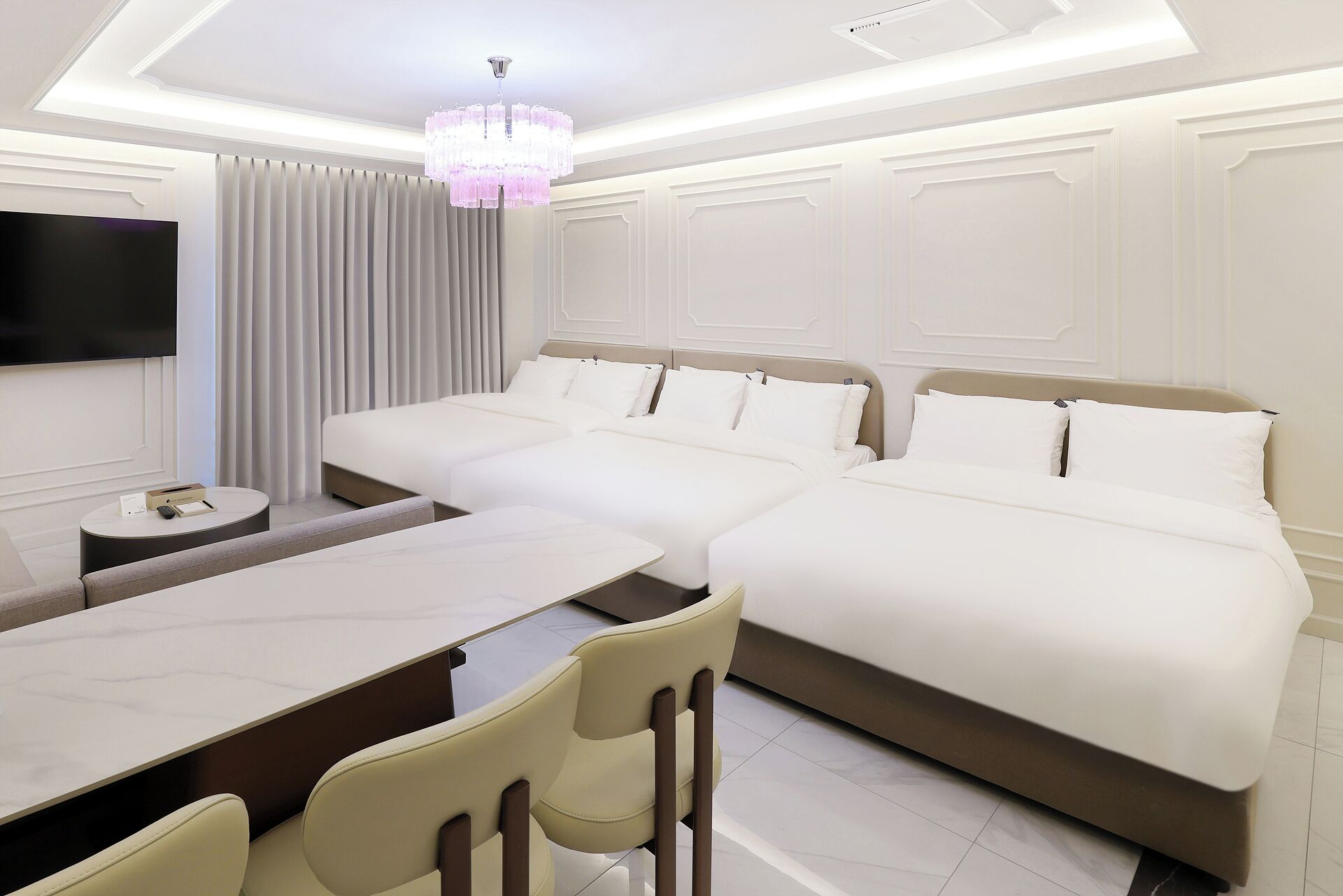 A hotel room with a large bed, a desk, and a television.