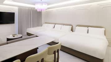 A hotel room with a large bed, a desk, and a television.