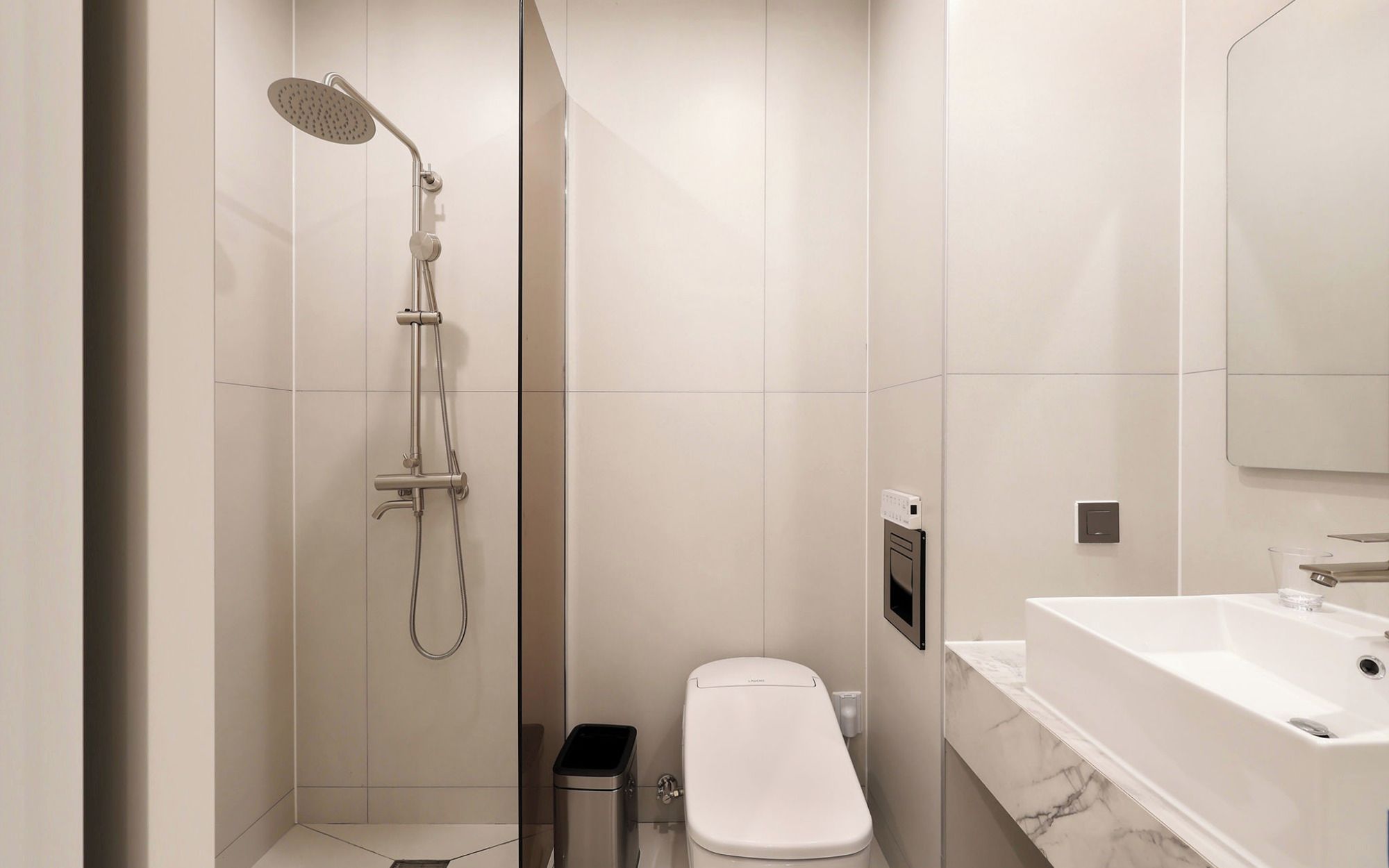 A modern bathroom with a walk-in shower, toilet, and a large bathtub.