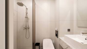 A modern bathroom with a walk-in shower, toilet, and a large bathtub.