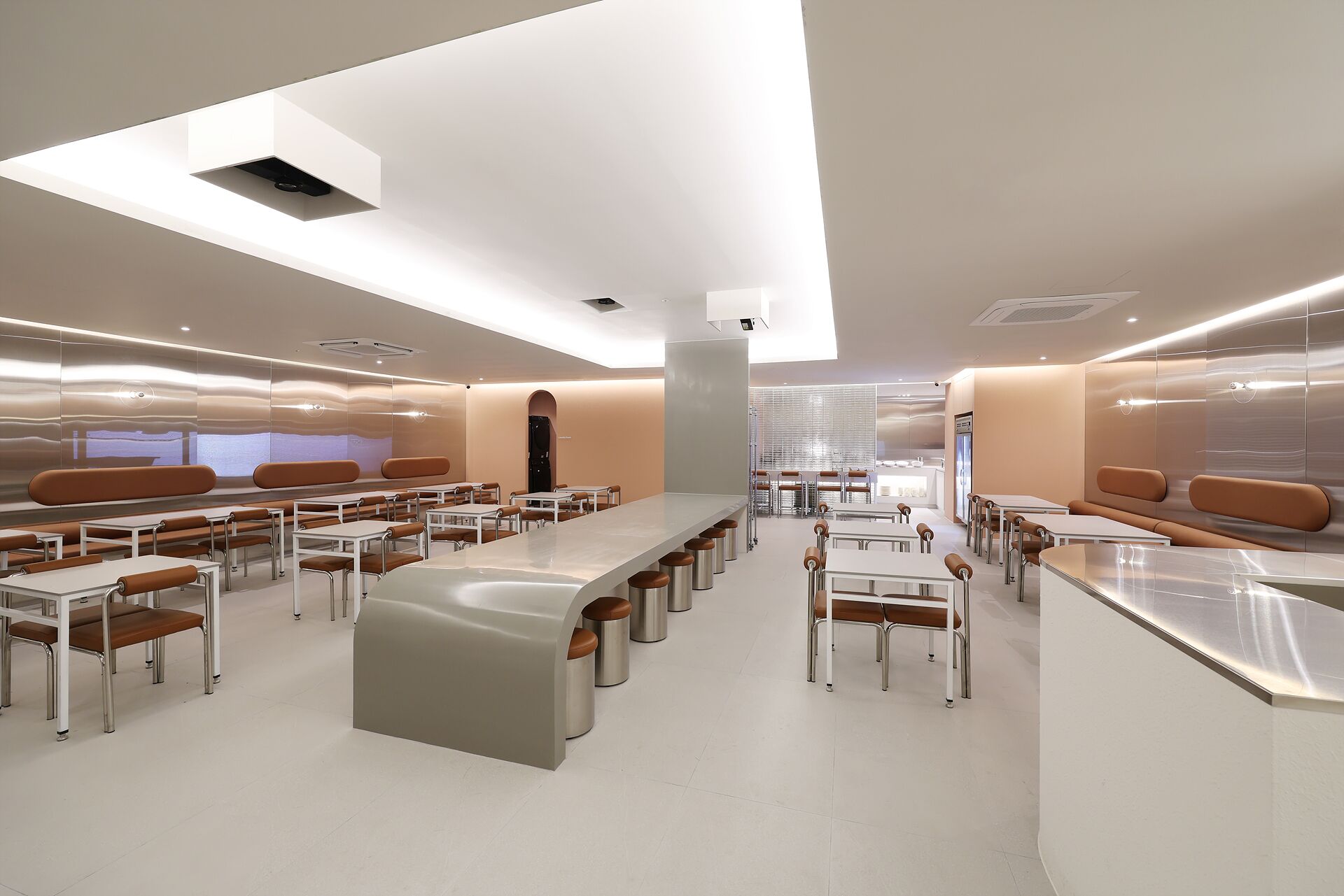 Un restaurant moderne doté d’un bar central, de nombreux espaces de restauration, notamment des banquettes et des tables, et d’un décor intérieur contemporain.