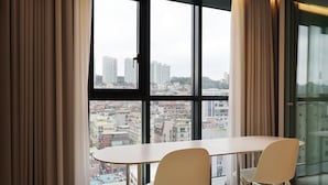 A modern room with a large window, two white chairs, and a table.