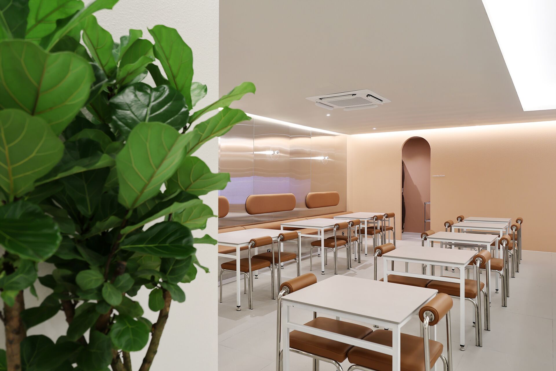 A modern, well-lit room with tables and chairs arranged for dining or meetings.