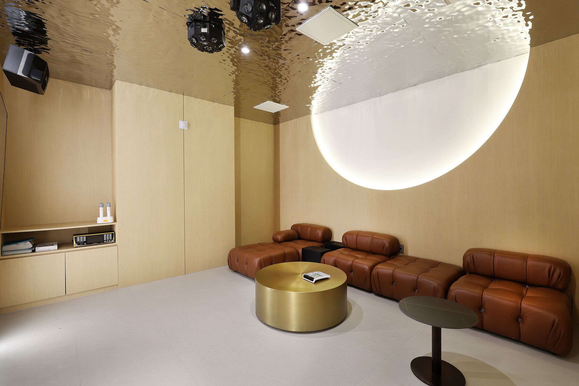A modern interior with a sofa set, a round gold table, and a small round table.