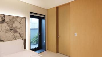 Un dormitorio con una cama, una puerta que da a un balcón y una pared de mármol.