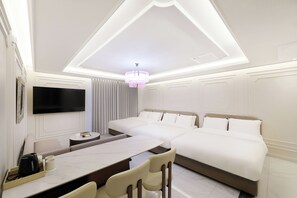 A modern hotel room with a large bed, a flat-screen TV mounted on the wall, a dining area with a table and chairs, and a chandelier. - HotelTheDeisngers SNU (Seoul)