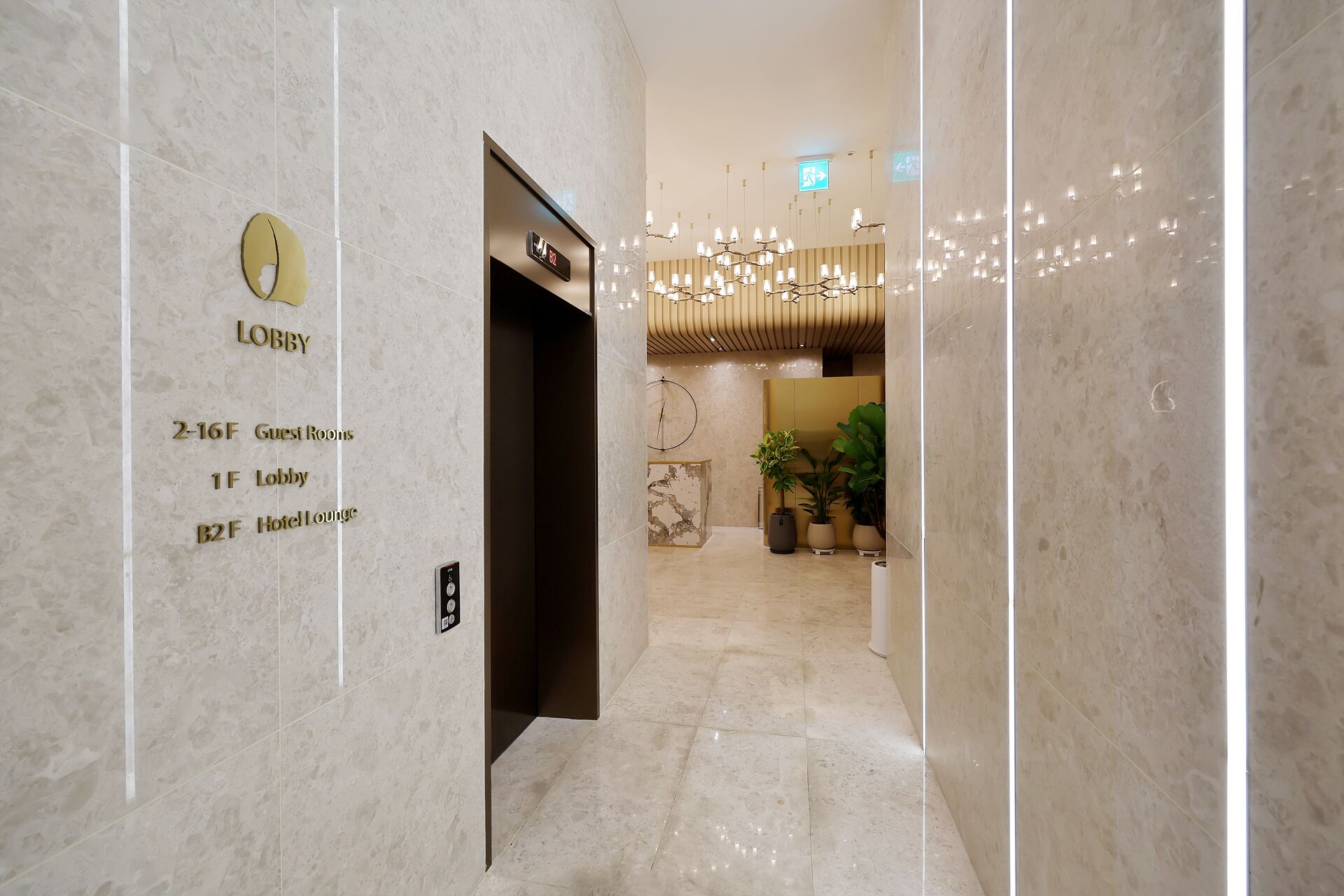 A hotel lobby with a marble floor, a reception desk, and a sign indicating guest rooms and hotel lounge locations.