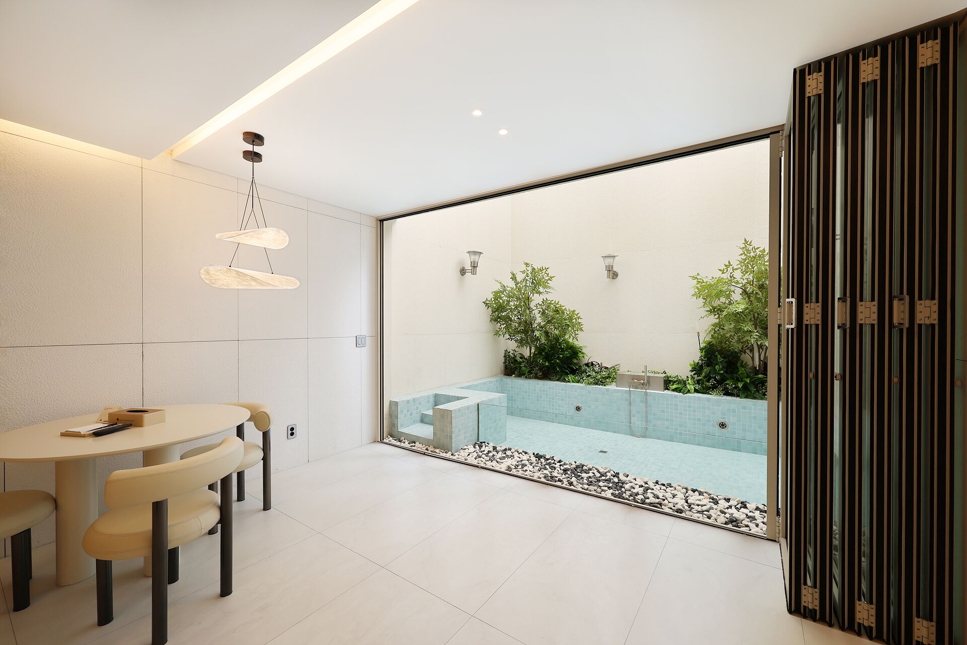 Un interior moderno con comedor, un espacio exterior con piscina y puerta corrediza.