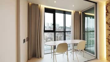 A modern room with a large window, a table, and two chairs.
