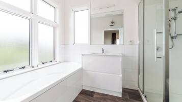 Een douche, handdoeken, zeep, toiletpapier