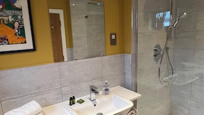 A bathroom with a shower, sink, and cabinets.
