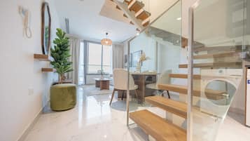 A modern interior with a staircase, a dining area, and a living space.
