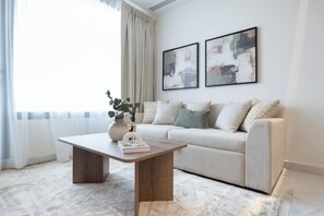 Ein modernes Wohnzimmer mit einer Couch, einem Couchtisch und zwei abstrakten Bildern an der Wand.