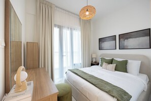 Ein Hotelzimmer mit einem Bett, einem Schreibtisch, einem Stuhl, einer Lampe und zwei Bildern an der Wand.