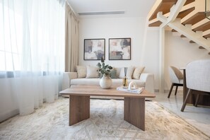 Uma sala de estar moderna com sofá, mesa de centro e obras de arte na parede.