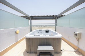 Ein Whirlpool auf einer Dachterrasse mit freiem Blick auf die Landschaft.