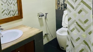 A bathroom with a toilet, sink, and shower curtain.
