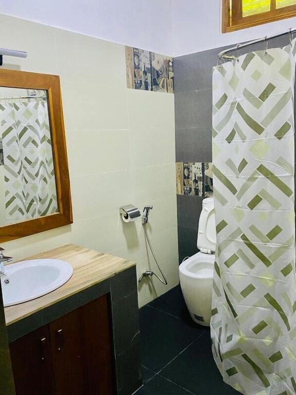 Une salle de bain avec des toilettes, un lavabo et un rideau de douche.