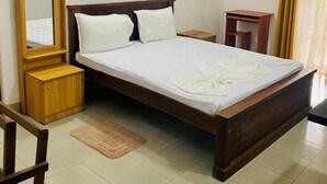 A bedroom with a wooden bed, a nightstand, a mirror, and a window with curtains.