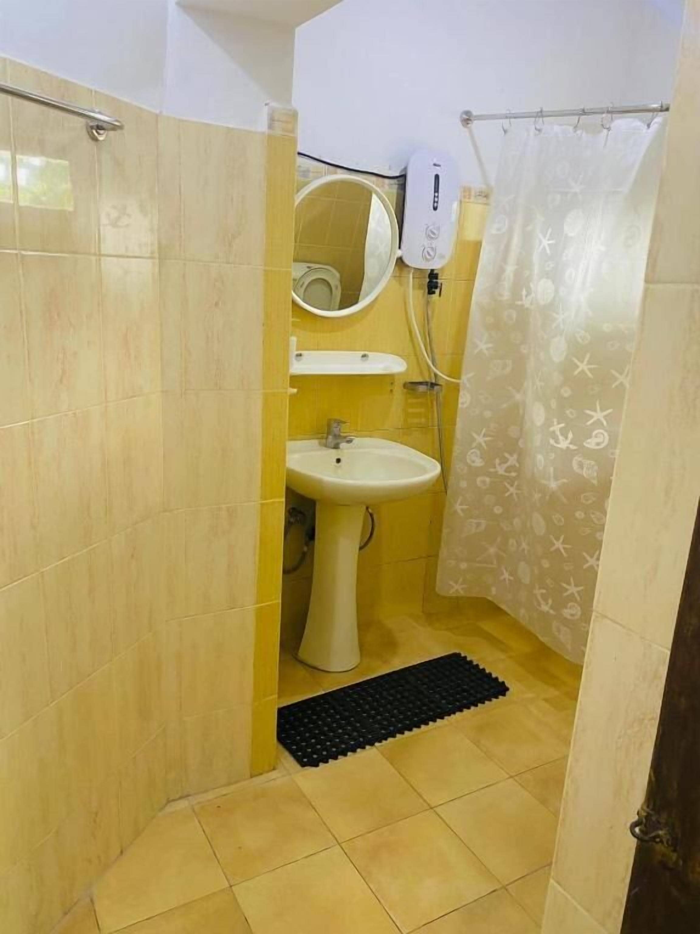 A bathroom with a sink, mirror, and shower curtain.