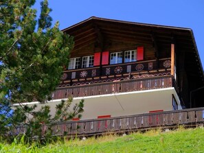 A wooden chalet with a balcony, surrounded by greenery. - Lill Britta 3, obere Wohnung Appartement/Fewo, Dusche und Bad, WC, Komfort by Interhome (Arosa)