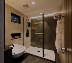 A modern bathroom with a glass-enclosed shower, a standalone sink, and a towel rack.