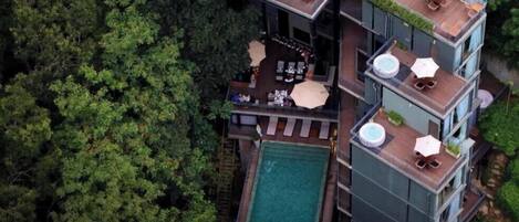 Un edificio de varios pisos con terraza al aire libre y piscina.