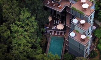 Un edificio de varios pisos con terraza al aire libre y piscina.
