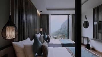 Habitación de hotel moderna con una cama grande, una cama más pequeña y vistas a la montaña.