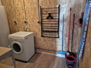 A laundry area with a washing machine, a drying rack, and cleaning tools. - A 3-star vacation home with great amenities. (Le Tholy)