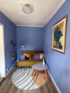 A bedroom with a bed, a round table, a floor lamp, and a painting on the wall. - Casa Vinea – a getaway in the heart of the Saale-Unstrut wine region. (Freyburg (Unstrut))