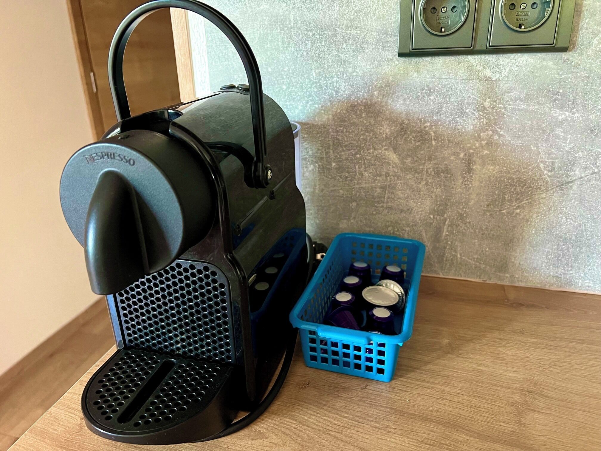 Een Nespresso koffieapparaat met een blauwe bak met koffiecups.