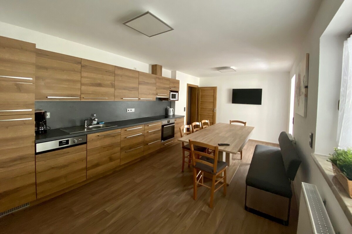 Una cocina moderna con armarios de madera, una mesa de comedor y sillas.