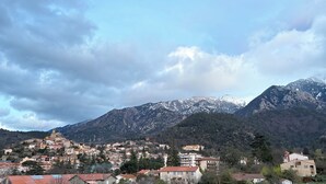 A mountainous landscape with a town nestled at the base, featuring traditional architecture and a prominent church. - A cozy, fully equipped home with a breathtaking view (Vernet-les-Bains)