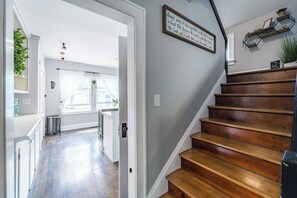 A staircase leading to a second floor with a framed inspirational quote on the wall.